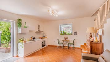 Una cocina compacta con comedor, un sofá y un ventanal con vistas.