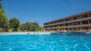 A hotel with a swimming pool, multiple balconies, and a clear blue sky. - Terrace Apartment for 4 in Pals (Pals)