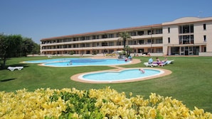 A hotel with multiple swimming pools, a well-maintained lawn, and a large building with balconies. - Terrace Apartment for 4 in Pals (Pals)