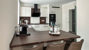 Eine moderne Küche mit einer zentralen Kochinsel, Barhocker und Blick in den Essbereich.