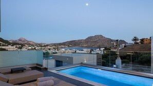 Piscina no terraço com vista desobstruída para uma montanha e a cidade ao fundo.