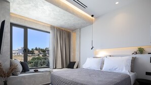 Quarto moderno com uma cama grande, uma janela com vista e uma mesa de cabeceira.