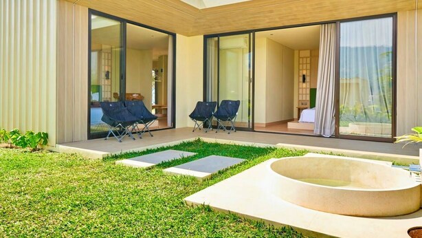 Uma casa moderna com um pátio, uma piscina e um quarto com uma janela grande.