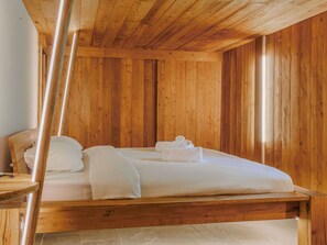Ein Zimmer mit Holzboden, einem Bett und einem Nachttisch.