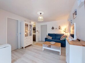 A modern living room with a sofa, coffee table, and a white cabinet. - Evasion Marine by Interhome (Saint Georges de Didonne)