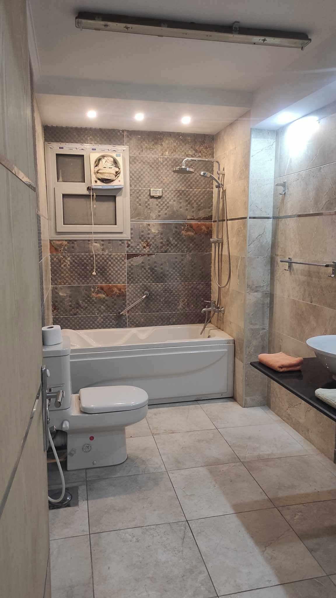 Un baño con bañera, inodoro y zona de ducha.