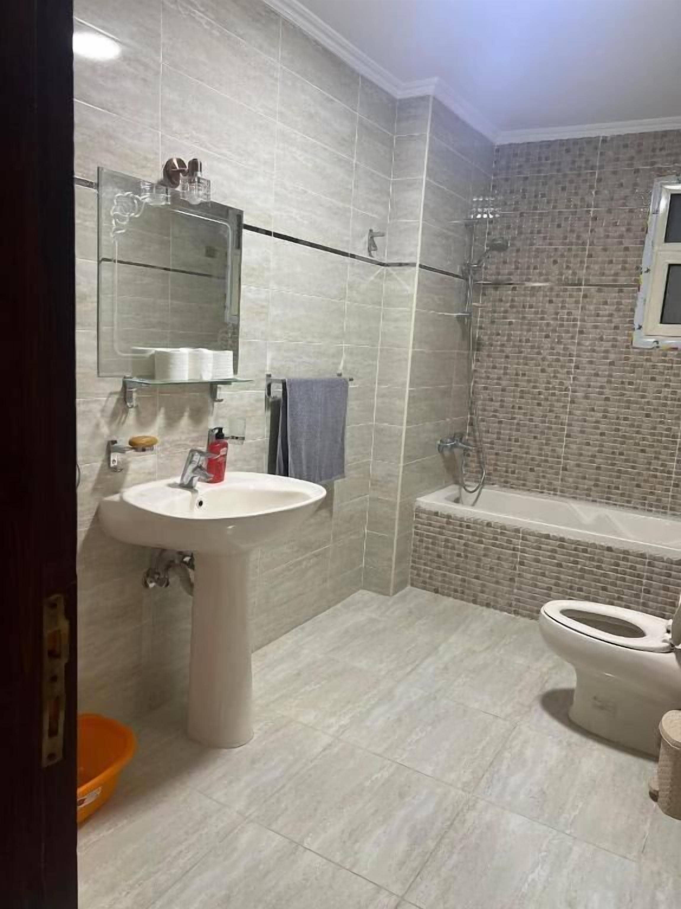 A bathroom with a sink, mirror, and shower.