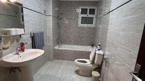 Un bagno con lavandino, WC, vasca e doccia.