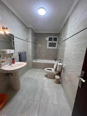 A bathroom with a sink, toilet, bathtub, and shower. - Comfy Luxurious Apartments East Cairo  (Cairo Governorate)