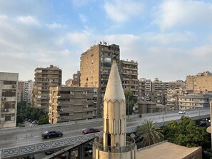 A cityscape with a prominent tower and a busy road with vehicles. - Comfy Luxurious Apartments East Cairo  (Cairo Governorate)