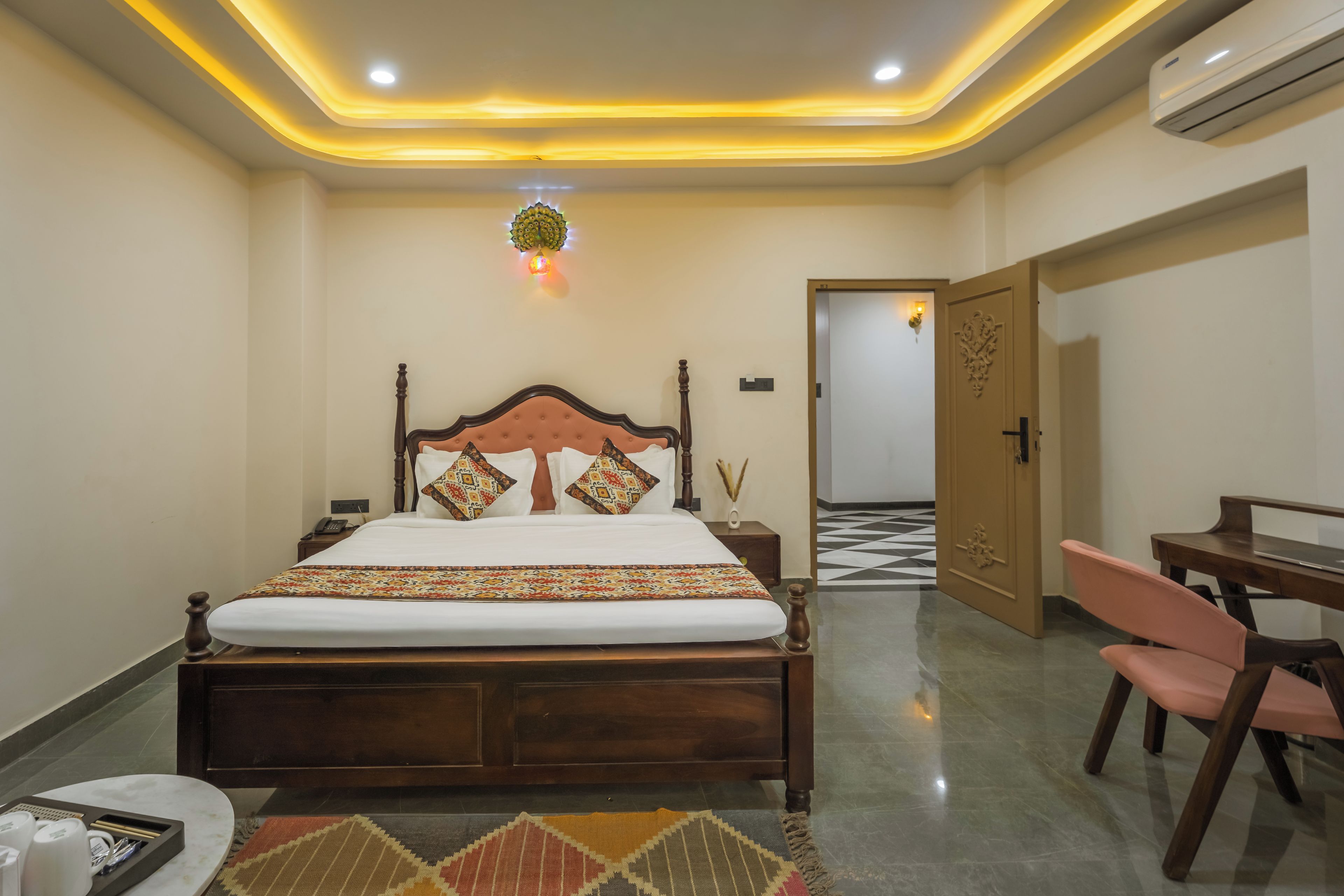 Una habitación de hotel con cama, mesita de noche, silla y escritorio.