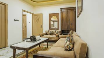 A living room with a sofa, a coffee table, a cabinet, and a door.