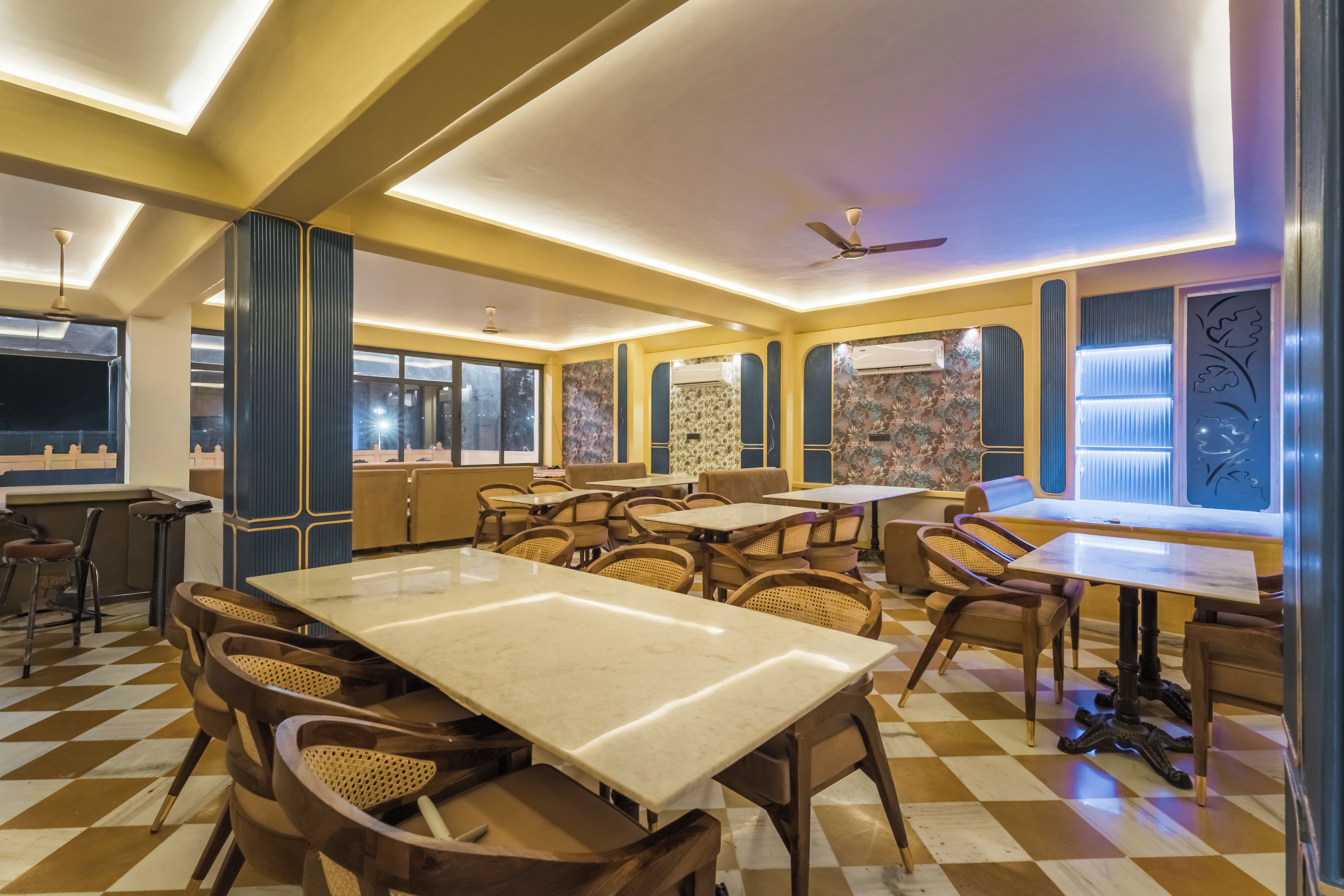 Un restaurant avec un sol à carreaux, des tables et des chaises en bois, et un ventilateur au plafond.