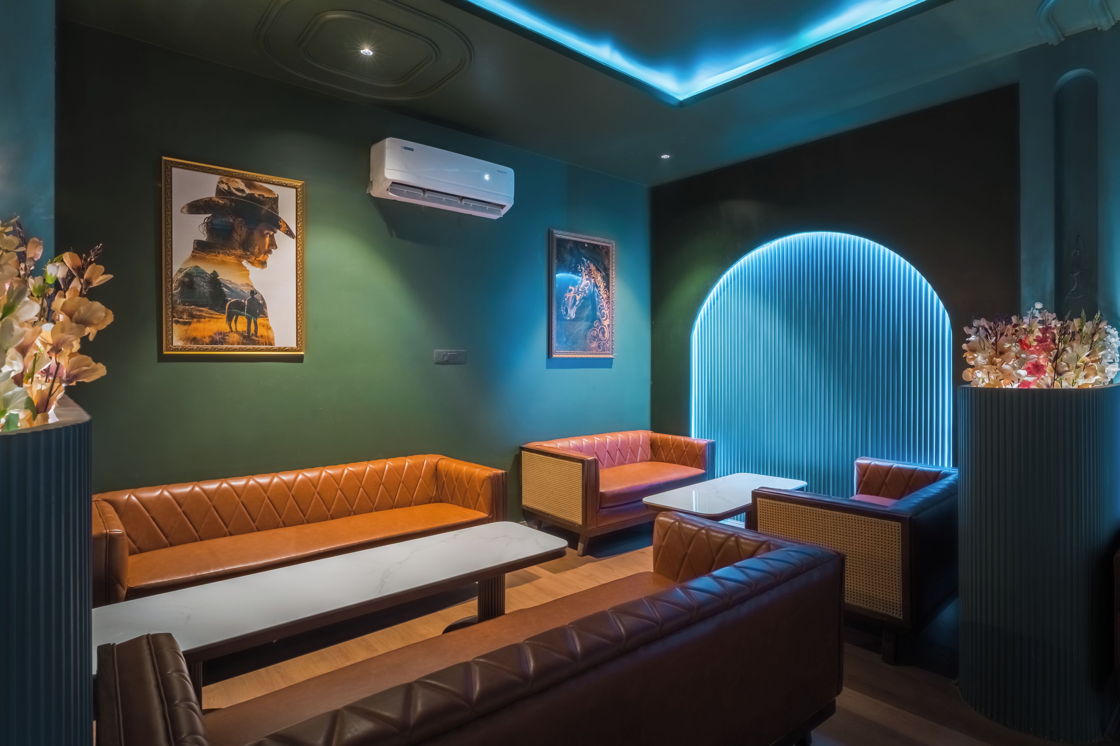 Um lounge moderno com assentos de couro, uma mesa central e arte decorativa nas paredes.