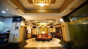 A hotel lobby with a central seating area, a chandelier, and a reception desk. - Spacious fully self-contained 1-bedroom condo in Angeles City near Clark (Angeles)