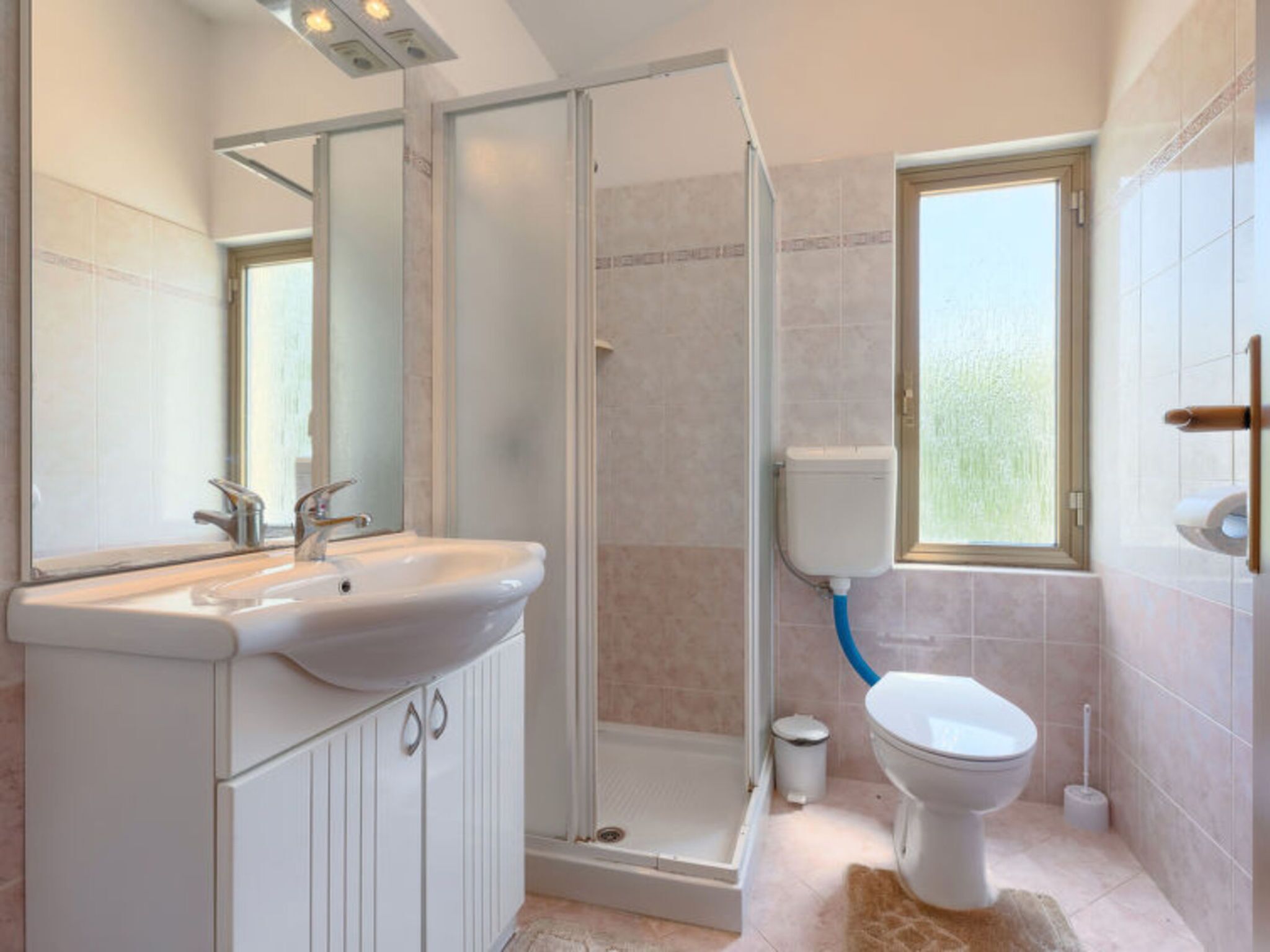 Une salle de bain avec douche, toilettes et lavabo.