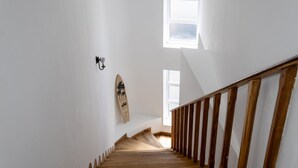En trætrap med en hvid væg og et surfbræt på væggen.
