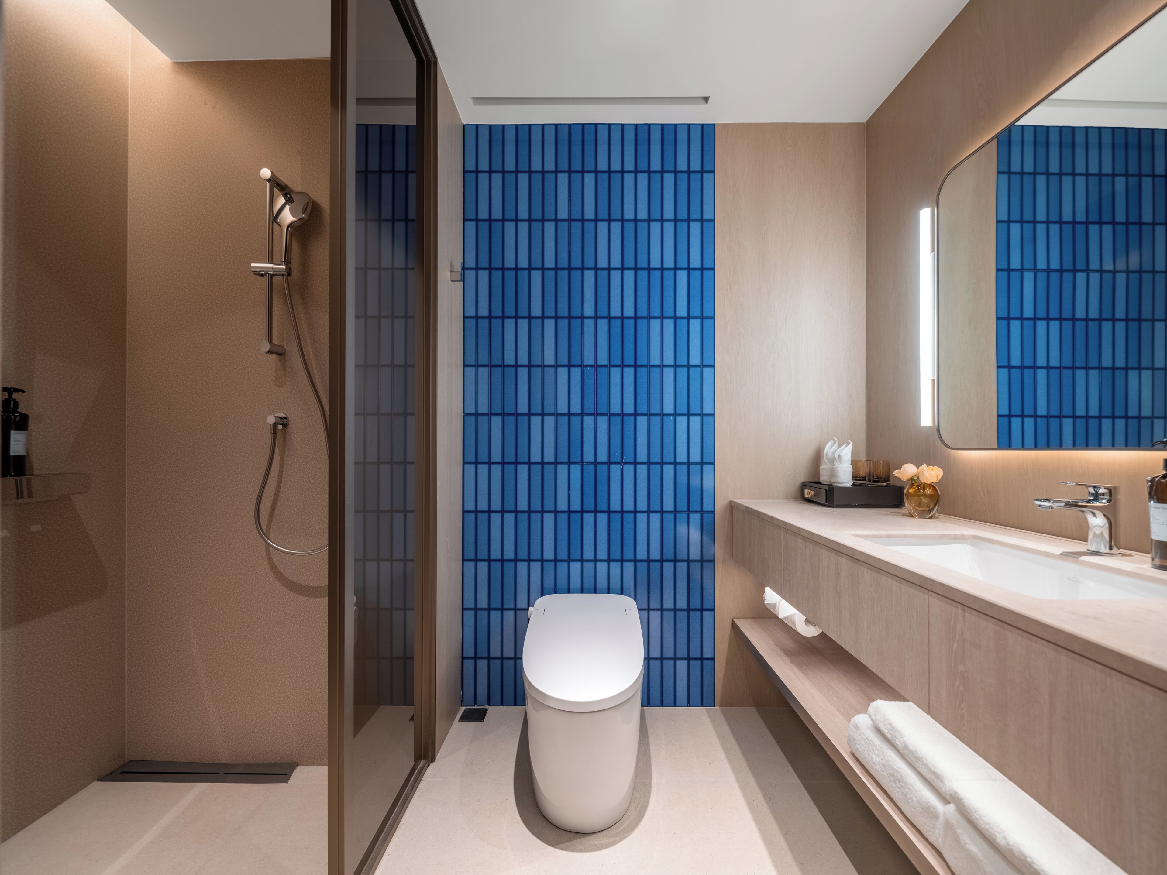 A modern bathroom with a shower, toilet, and vanity.