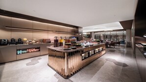 A modern kitchen with a central island, built-in appliances, and a seating area with a view.