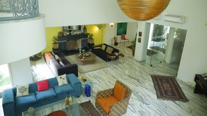 A spacious living area with a blue sofa, a patterned armchair, and a coffee table.