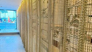 A corridor with a wall covered in golden chains.