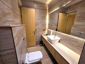 A modern bathroom with a toilet, sink, and mirror. - Townhouse Rambagh Amritsar (Amritsar)