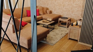 A modern living room with a sectional sofa, a coffee table, and a patterned wall. - Plein Sud La Roche en Ardenne (La Roche-en-Ardenne)