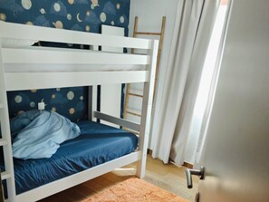 Ein Etagenbett mit blauer Matratze und einer Wand mit einem Weltraum-Wandgemälde.