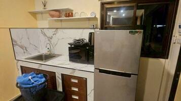 A compact kitchen with a refrigerator, a sink, and a small countertop.