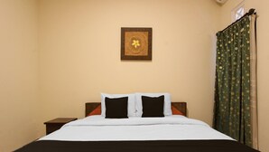 A bed with white and black bedding, a wooden headboard, and a small bedside table. - Spacious 2BR Villa Near Malioboro (Yogyakarta)