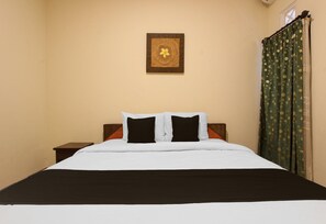 A bed with white and black bedding, a wooden headboard, and a small bedside table. - Spacious 2BR Villa Near Malioboro (Yogyakarta)