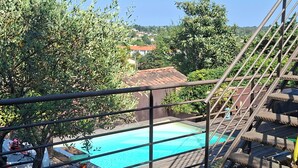 Ein Poolbereich mit Holzboden, Metallgeländer und umliegender Bepflanzung.