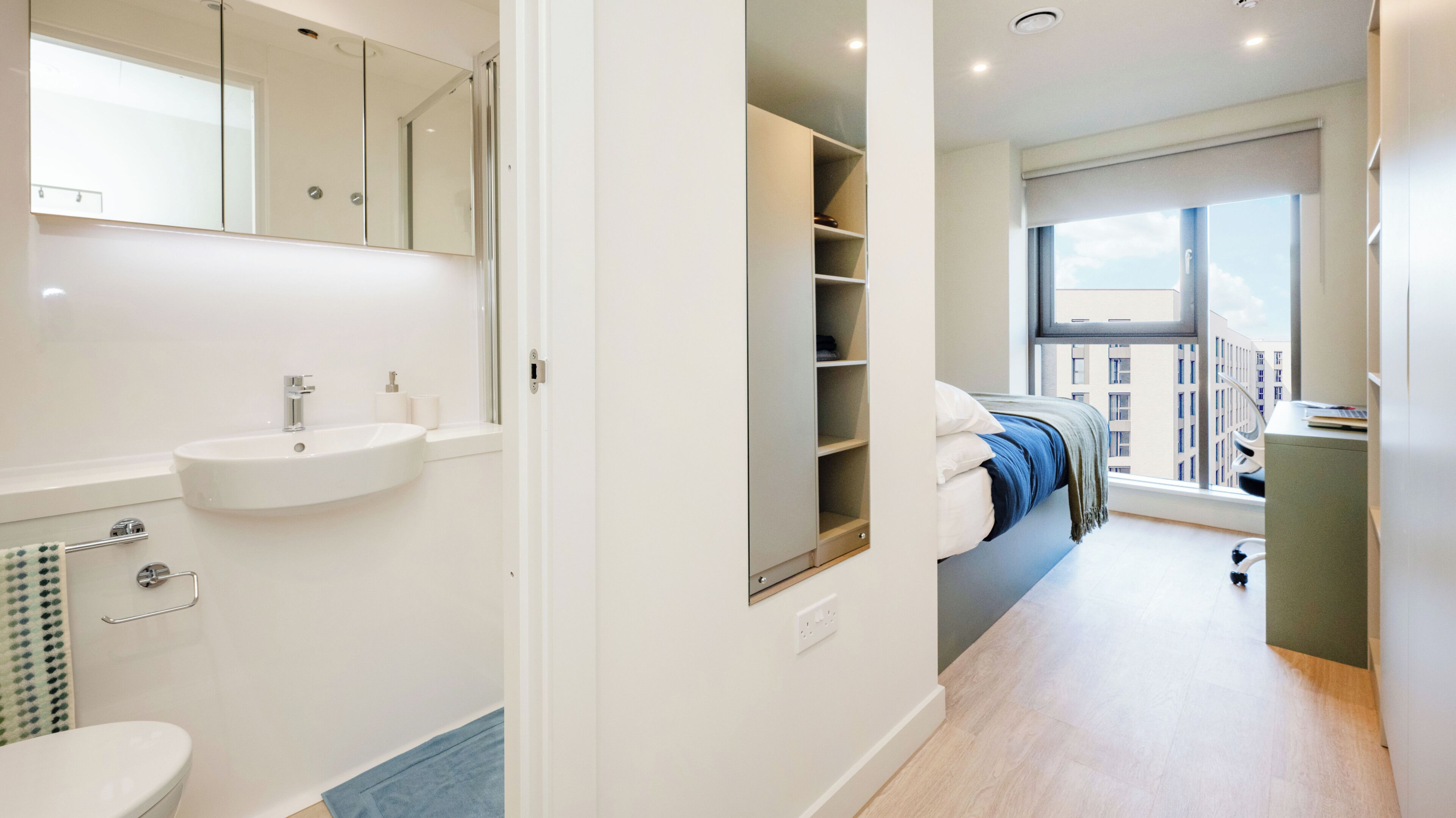 A modern bathroom with a sink, mirror, and toilet.