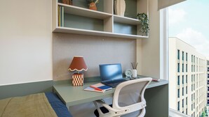 Un espacio de trabajo con una computadora portátil, una lámpara de escritorio y una silla.