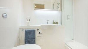 A bathroom with a toilet, sink, shower, and a towel rack. - For Students Only - City Wharf in Glasgow (Glasgow)