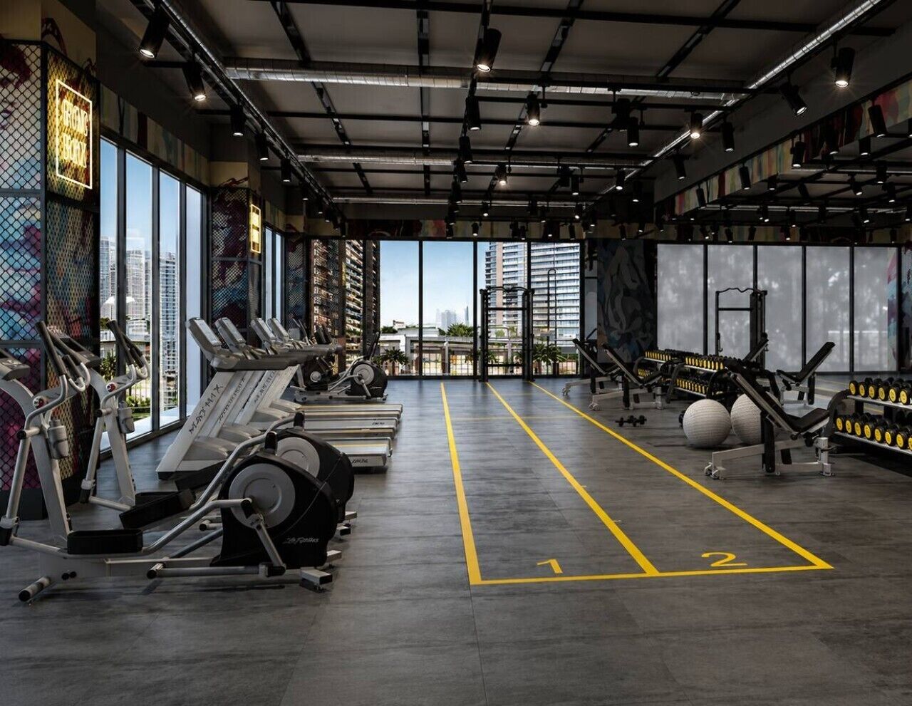 Una palestra con macchinari cardio, attrezzature per l'allenamento con i pesi e un'ampia finestra che si affaccia sulla città.