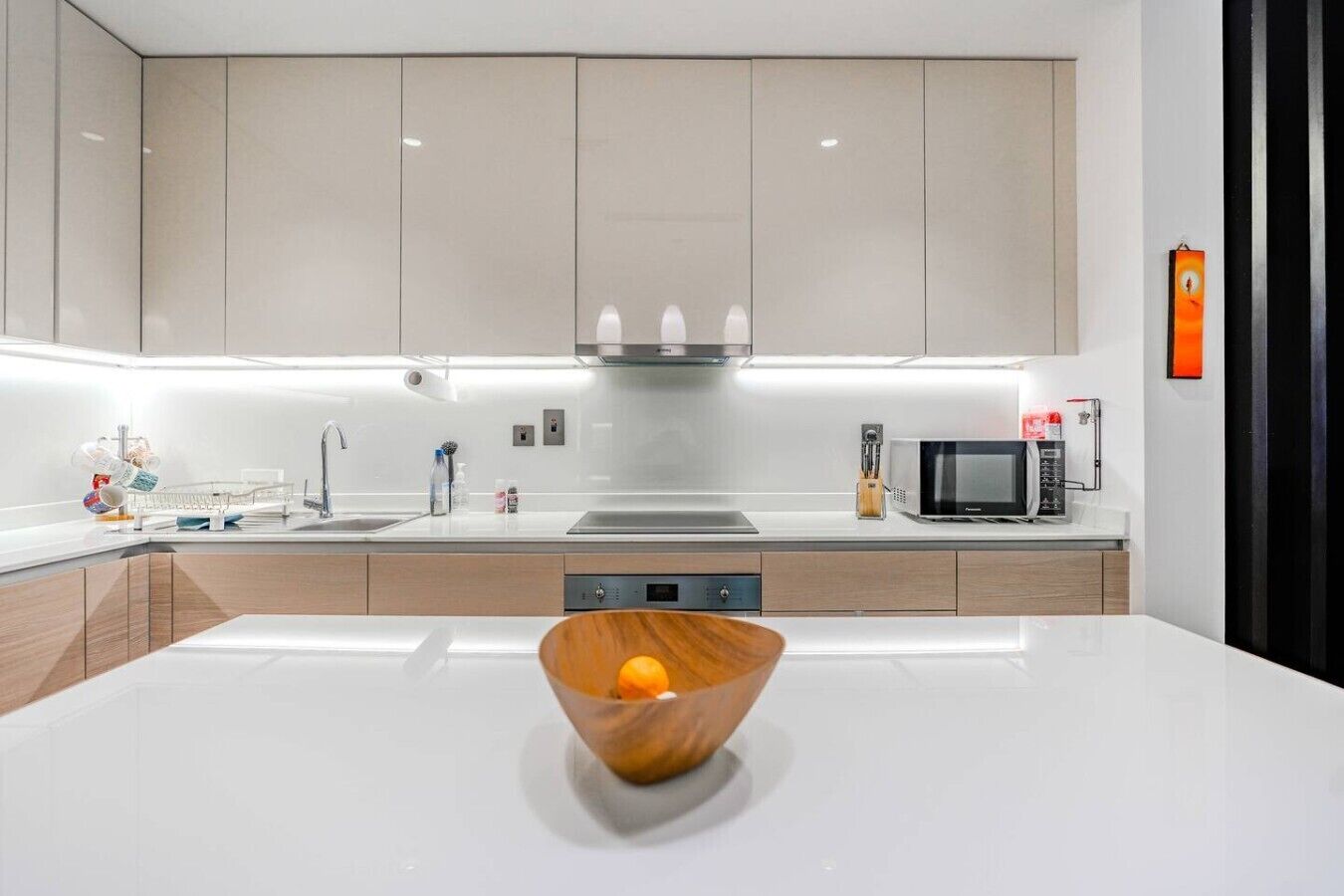 A modern kitchen with a central island, stainless steel appliances, and a minimalist design.