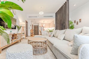 Ein modernes Wohnzimmer mit einer Couch, einem runden Couchtisch und einem Bücherregal.