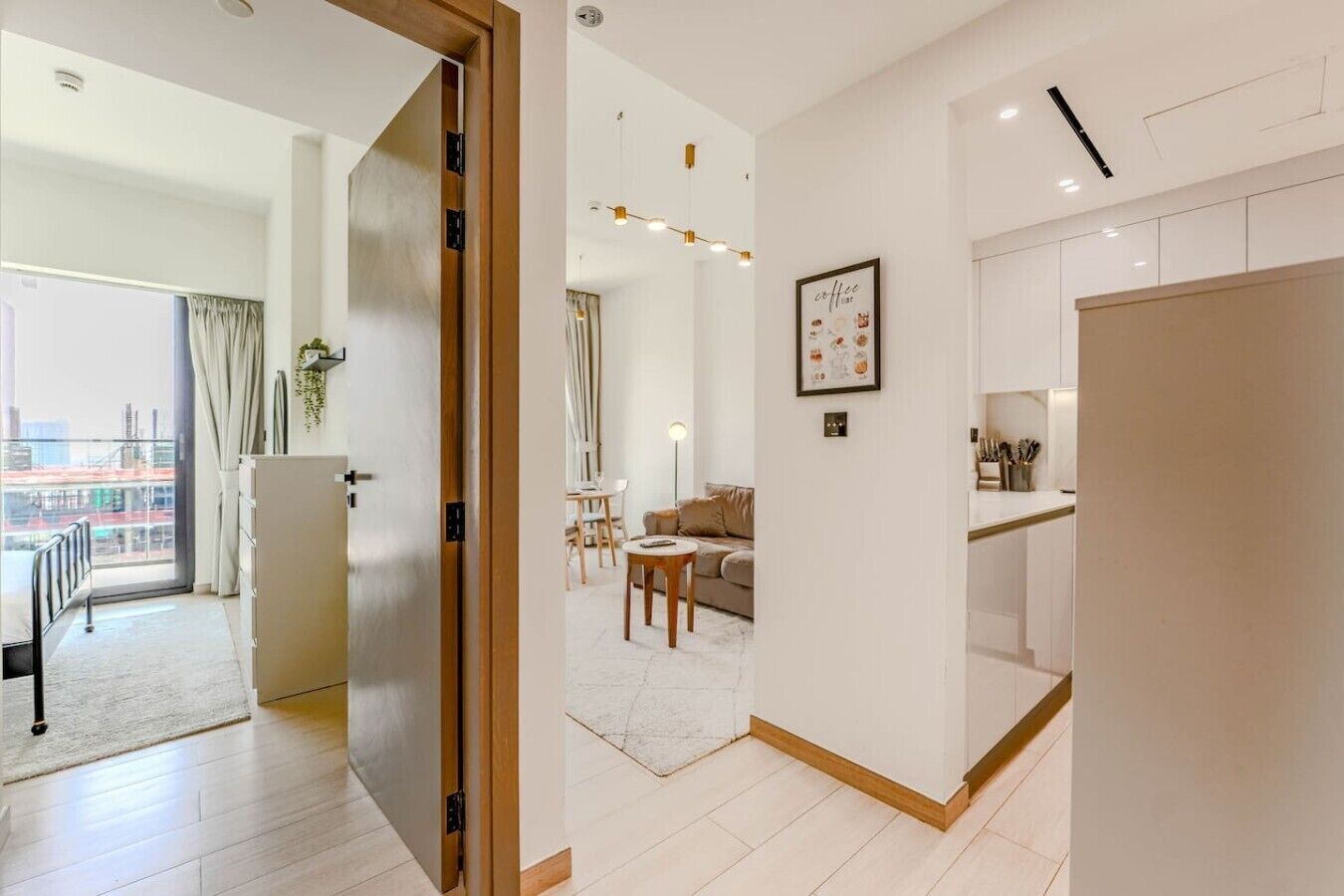 Een moderne hotelkamer met balkon, eethoek en keuken.