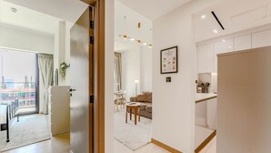 Ein modernes Hotelzimmer mit Balkon, Essbereich und einer Küche.