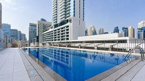 A swimming pool with a cityscape in the background. - HAVN - 1 Bedroom in Azure, 5 mins to DMCC metro (Dubai)