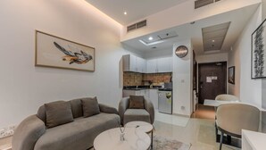 Un salon moderne comprenant un canapé, des fauteuils, une table basse et un coin repas avec une table et des chaises.