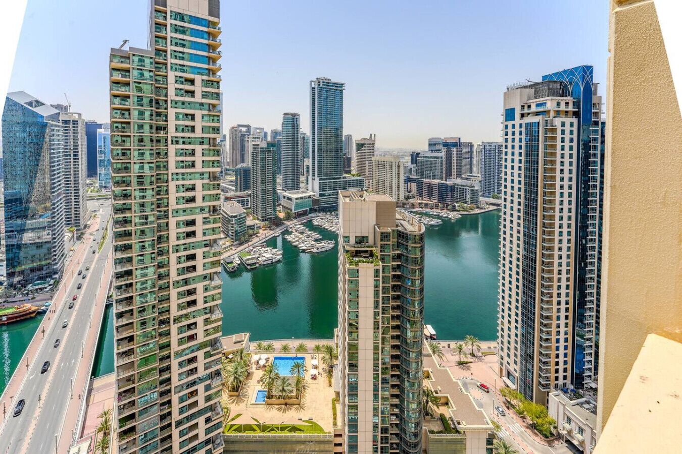 A high-rise building with a marina and boats.