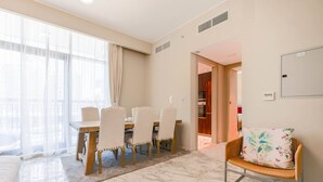 Una sala de estar moderna con comedor, un sofá y una silla de mimbre.