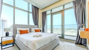 Una moderna camera d'albergo con un letto grande, un comodino, una scrivania e vista sulla città.