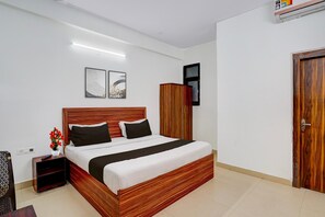 Ein Schlafzimmer mit einem hölzernen Bett, einem Nachttisch, einem Kleiderschrank und zwei gerahmten Bildern an der Wand.