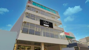 A multi-story building with a sign reading 'Collection Company-Service.' - Collection O Noida Sector 52 Metro Station (Noida)