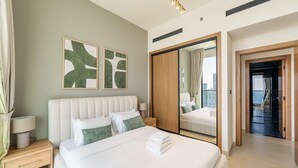 Ein modernes Hotelzimmer mit einem großen Bett, einem Nachttisch, einem Spiegel und Blick auf die Stadt.