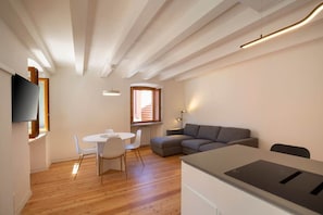 A modern apartment with a dining area, sofa, and kitchenette. - Paola's House - In the Heart of Bardolino (Bardolino)
