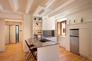 A modern kitchen with white cabinetry, a central island, and a built-in oven. - Paola's House - In the Heart of Bardolino (Bardolino)
